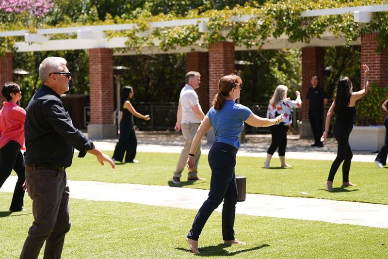 Group of adults experiencing Tai Chi outdoors at the at SITE SoCal May 7 Educational Experience + Lunch event.