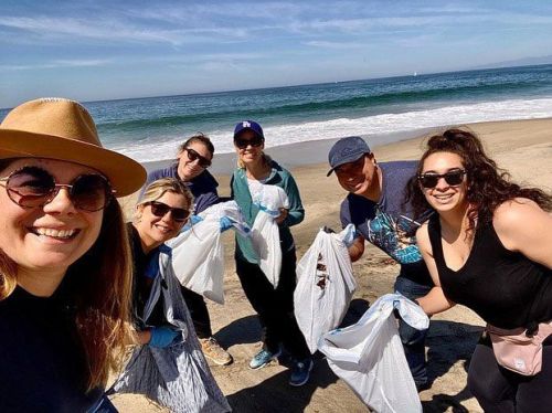 Group of people participating in a beach clean-up.
